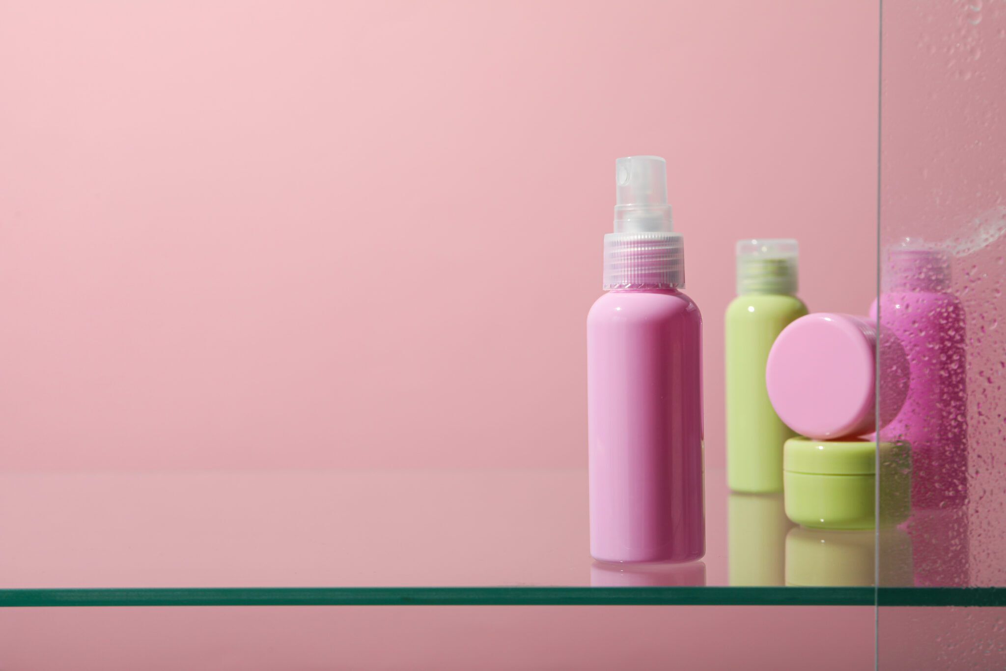 Pink wall in shower with glass shelf