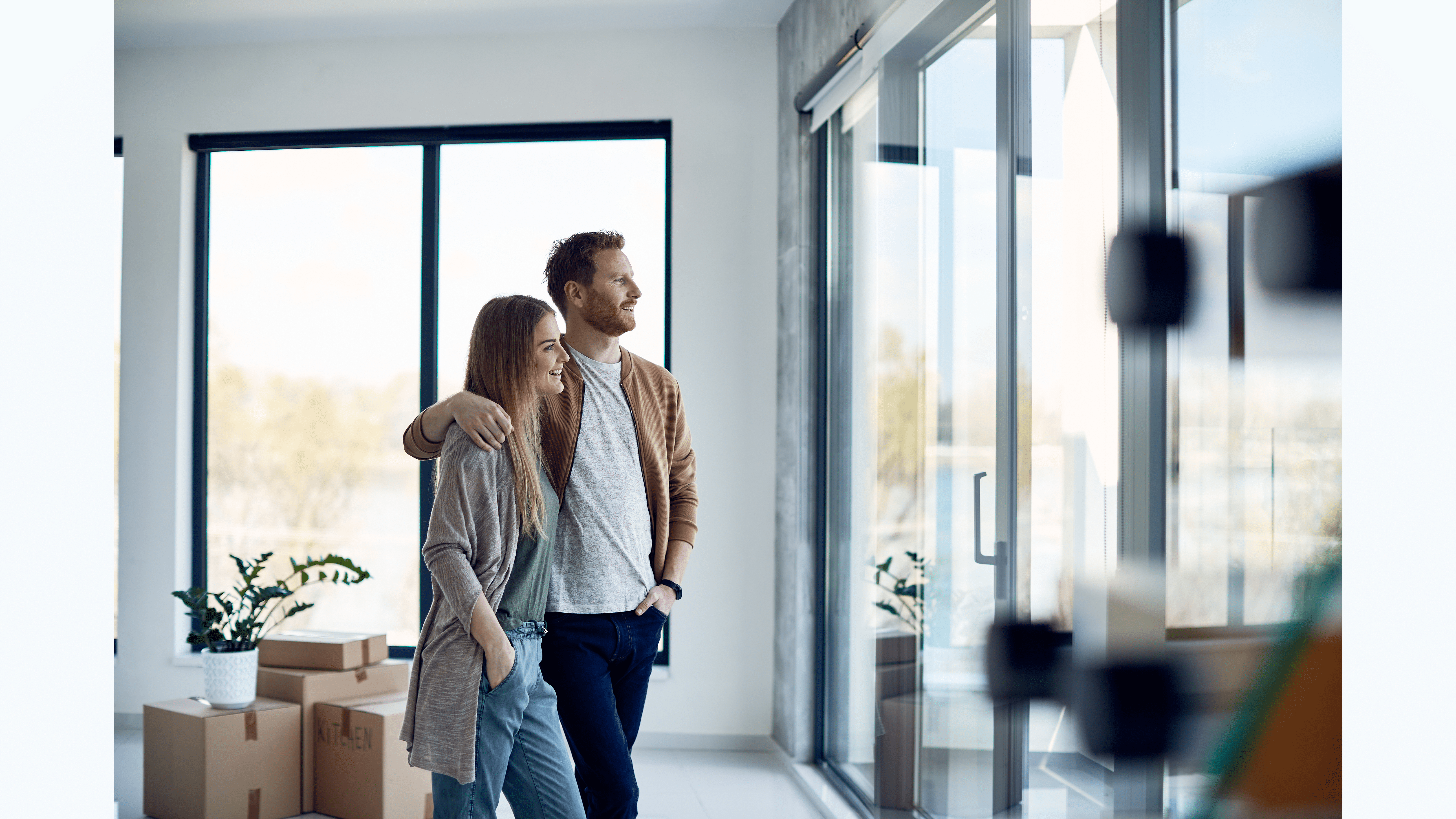 Happy couple admiring view from new windows