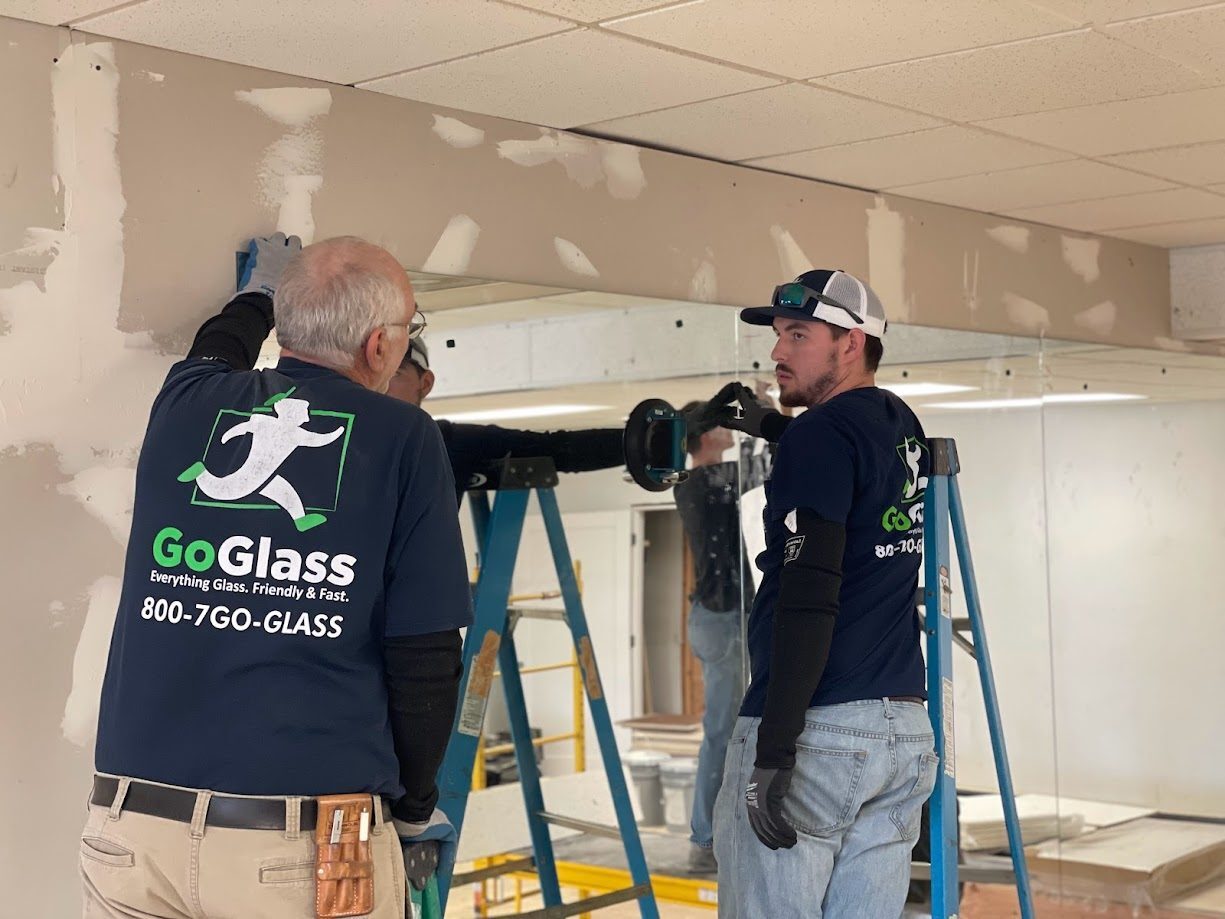 Two GoGlass employees install a floor-length mirror in Delmarva