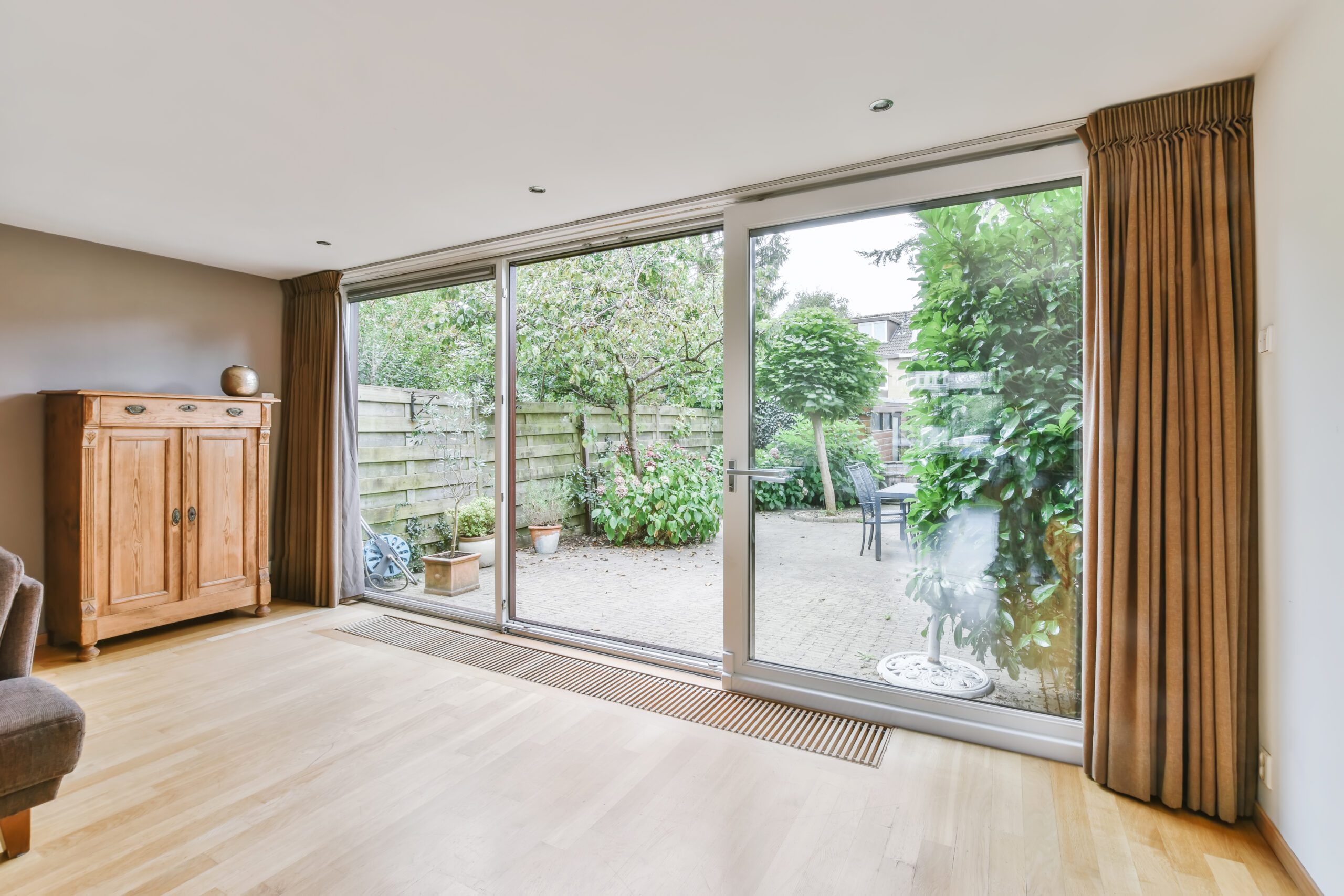 Spacious room with 3-lite replacement patio doors overlooking backyard garden