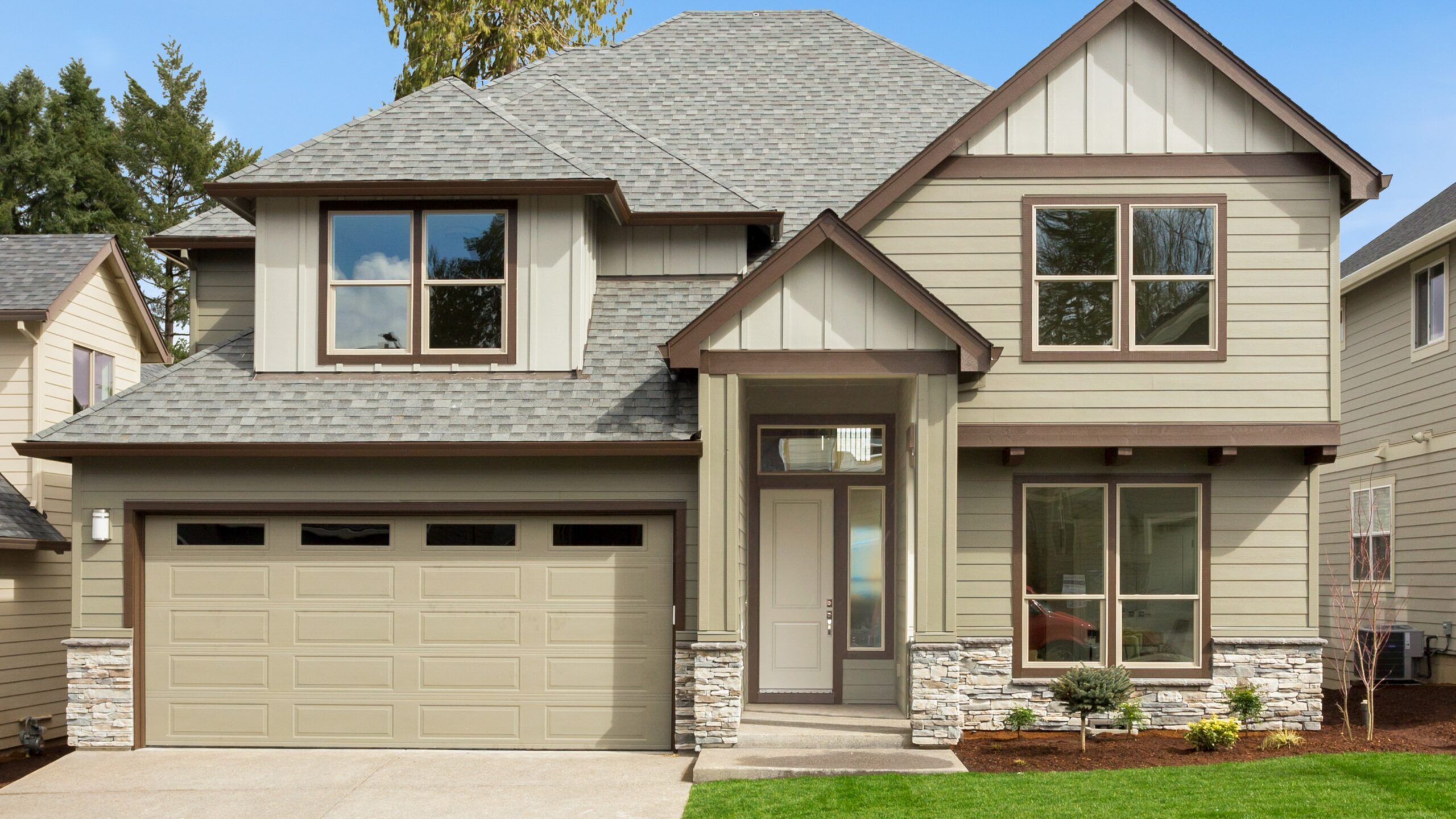 Grey home exterior with beautiful asphalt roofing and new replacement windows